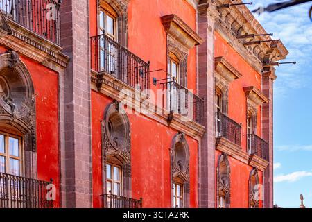 A low angle shot of a red building with balconies and windows. Stock Photo