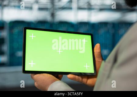 Evaluating hardware, green screen tablet and engineer in data center ...