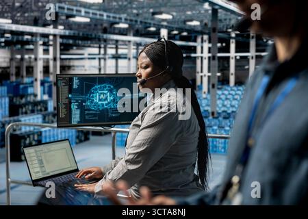 Server hub technicians diagnosing hardware failures using AI support systems, guiding users. Teamworking data center coworkers using headset mic, using automated AI scripts to resolve clients issues Stock Photo