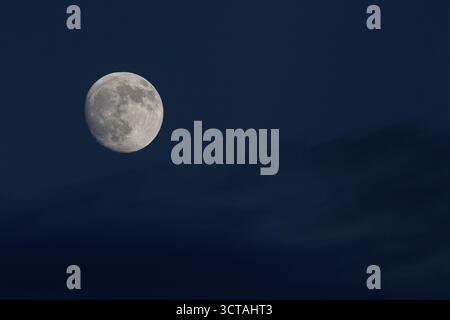 A 96% waxing gibbous moon in a cloudy sky. Kanagawa, Japan. Stock Photo