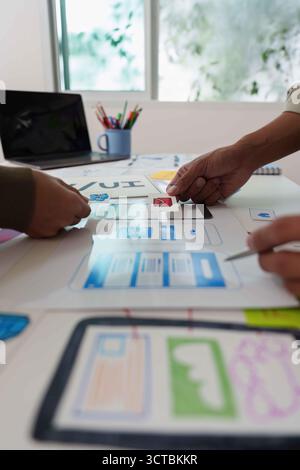 Collaborative UX UI Design Process. Team discussing wireframes and user interface layouts. Stock Photo