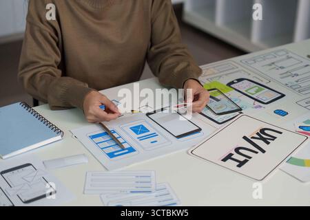 UX UI Design Process. Designer Creating Mobile App Wireframes and User Interfaces. Stock Photo