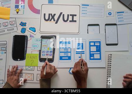 Collaborative UX UI Design. Team members working on mobile app wireframes and user interface. Stock Photo