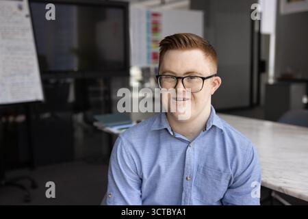 Happy young employee with Down syndrome working for inclusive company Stock Photo