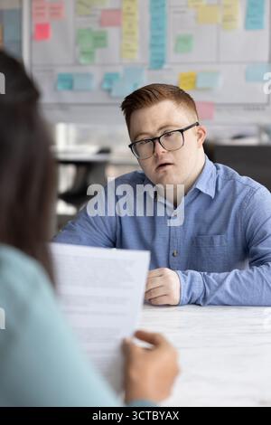 Serious professional man with Down syndrome talking to employer Stock Photo