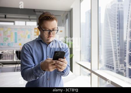 Inclusive company worker man with Down syndrome chatting on phone Stock Photo