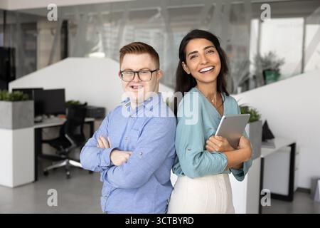 Two cheerful diverse colleagues posing together, standing close Stock Photo
