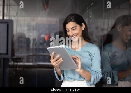 Cheerful Hispanic businesswoman working on successful project Stock Photo