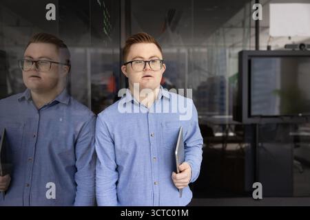 Serious young professional man in glasses having Down syndrome Stock Photo