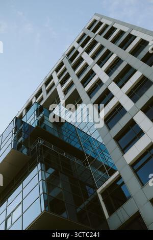 Modern Office Building Exterior Featuring Glass Facade Against Blue Sky Stock Photo