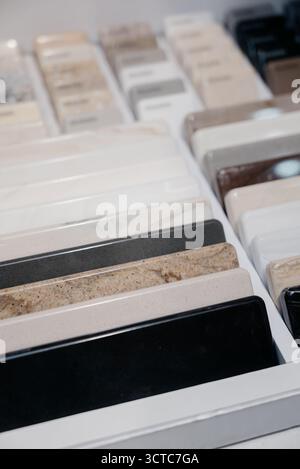 Close-up of acrylic stone countertop samples in different colors and textures. Selecting materials for the kitchen or bathroom: rows of artificial sto Stock Photo