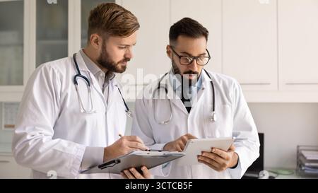 Two focused general practitioners engaged in medical case study Stock Photo