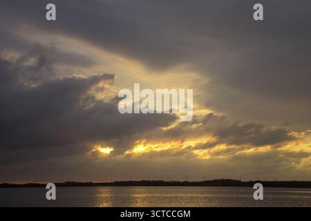 Dramatic sky sunset over ocean, climate change, wild cloud formations at sunset over the ocean Stock Photo