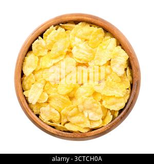 Corn flakes, or cornflakes in a wooden bowl. Breakfast cereal made from toasting flakes of corn or maize. Popular food item in American diet. Stock Photo