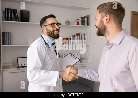Happy Hispanic general practitioner greeting male patient Stock Photo