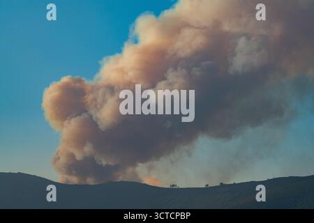 Large Smoke Plume Rising Over Scenic Landscape Stock Photo