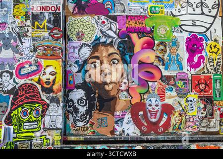 Wall covered in colourful graffiti and stickers in Brick lane, East London, UK Stock Photo