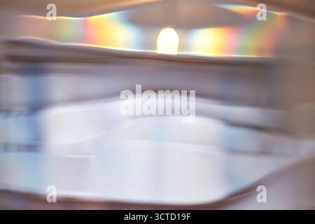 Abstract light refractions with soft colors through rippled glass surface capturing rainbow spectrum. Stock Photo