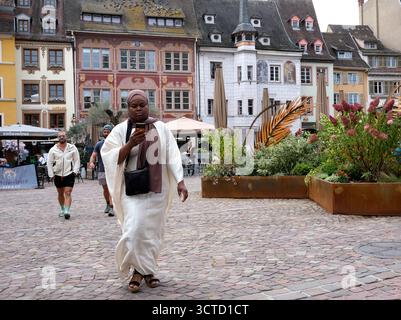 Woman using mobile phone while walking in Mulhouse, France. Stock Photo