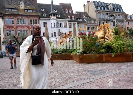 Woman using mobile phone while walking in Mulhouse, France. Stock Photo