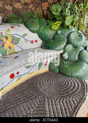 Artistic Mosaic Bench and Pebble Floor Detail - Decorative garden bench with ceramic mosaic and river stones forming a spiral floor pattern. Stock Photo