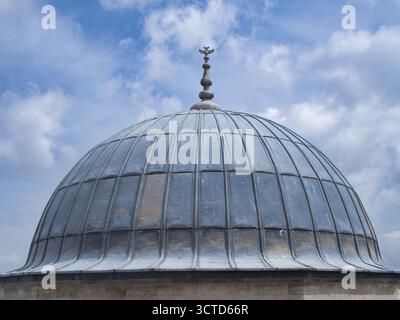 Historic Lead Dome and Ornate Finial - Architectural detail of a lead-covered dome and its unique ornate finial (alem) against a bright blue sky with Stock Photo