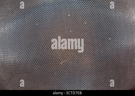 Close up of industrial stainless steel wire mesh with small square holes forming a geometric metallic grid pattern for filtration or construction Stock Photo