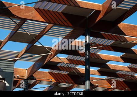 Captivating geometric patterns formed by sunlight filtering through wooden beams and translucent panels in modern building harmonizing with nature Stock Photo
