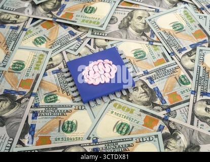 A chip using artificial intelligence or a neural network against a backdrop of dollars. The use of organic neurons in electrical engineering. AI inves Stock Photo