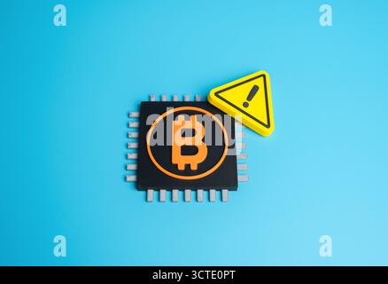 Bitcoin chip and warning sign. Cryptocurrency mining issues. Spam attacks on the Bitcoin network. Concept of cybersecurity, data protection, blockchai Stock Photo