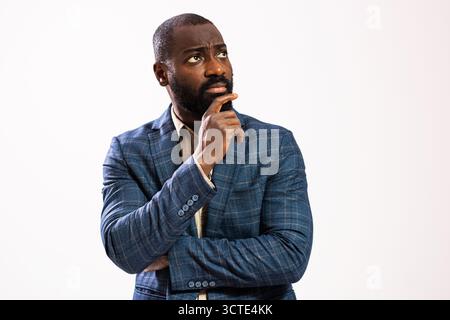 Portrait of worried and thoughtful African-american businessman. Black man in business suit is standing and thinking. Stock Photo