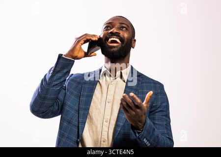 Portrait of happy and successful African-american businessman. Black man in business suit is talking on mobile phone. Stock Photo
