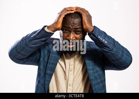 Portrait of tired and shocked African-american businessman. Black man in business suit is standing and having headache. Stock Photo