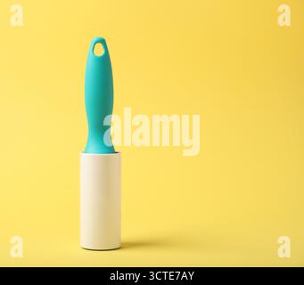 One lint roller on yellow background, space for text Stock Photo