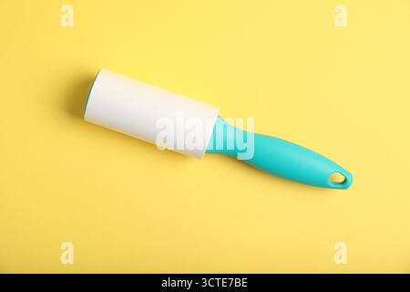 One lint roller on yellow background, top view Stock Photo