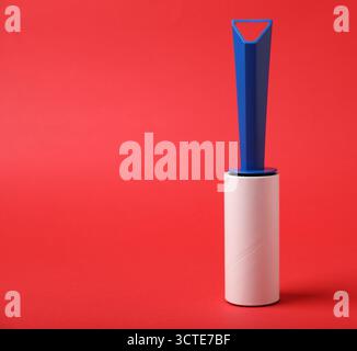 One lint roller on red background, space for text Stock Photo