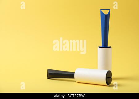 Two lint rollers on yellow background, space for text Stock Photo