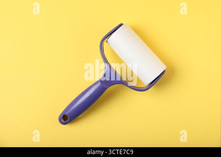 One lint roller on yellow background, top view Stock Photo