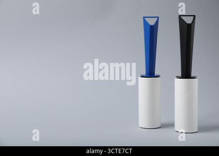 Two lint rollers on light grey background, space for text Stock Photo