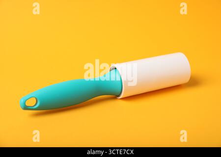 One lint roller on orange background, closeup Stock Photo