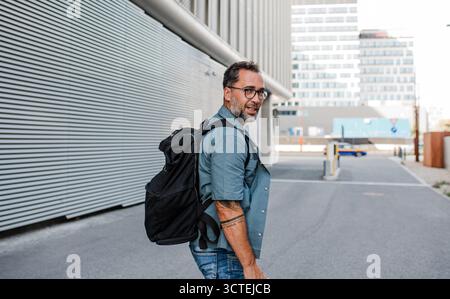 Handsome man with tattoos walking down the street. Stock Photo