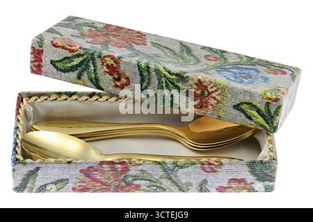 golden spoons in storage box isolated on white background Stock Photo