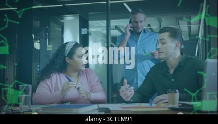 Discussing project ideas, colleagues marking documents on office table with markers and smartphone Stock Photo