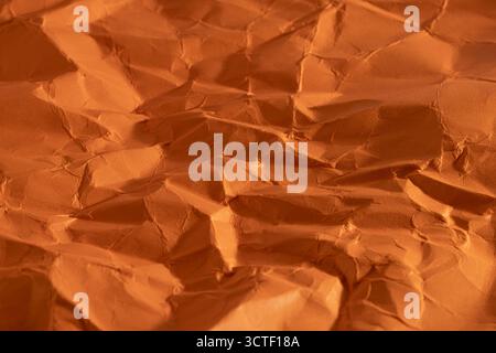 Orange crumpled paper as background, closeup Stock Photo