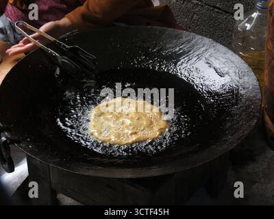 A flatbread frying in a large pan over an open flame. Stock Photo