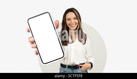 Smiling Woman Holding Smartphone in a Bright Setting Stock Photo