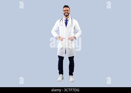Happy Arabic Male Doctor Smiling Posing Over Blue Studio Background Stock Photo