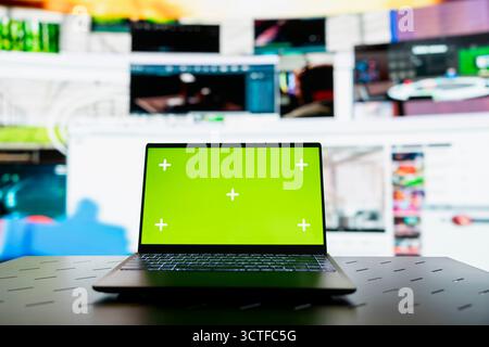 Close up of green screen laptop and VOD entertainment channels video collage. Chroma key notebook in front of virtual background displaying social network feed activity digital dashboard Stock Photo