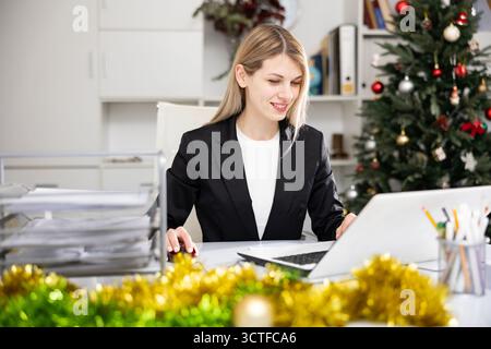 Woman office worker using laptop during workday Stock Photo