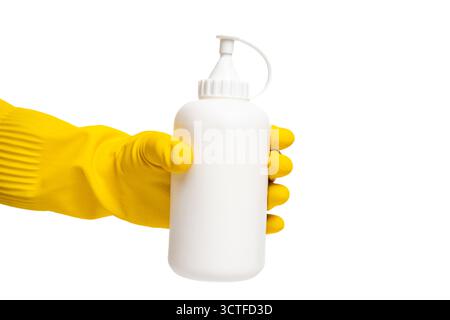 Yellow gloved hand holding white bottle on isolated white background. Bottle held by yellow glove. Cleaning, hygiene and safety concept Stock Photo